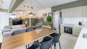 Una cocina moderna con horno empotrado y comedor con mesa y sillas de madera.