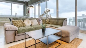 Una sala de estar moderna con sofá, reposapiés y una mesa de centro.
