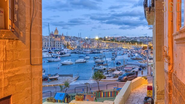 A harbor with numerous boats docked, a prominent building with a dome, and a view of the cityscape in the background. - Maltese Maisonette in Historic Isla with Sea Views (L-Isla)