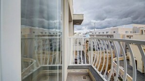 Un balcón con vistas a edificios residenciales bajo un cielo nublado.
