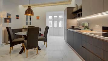 A modern kitchen with dark cabinetry, a round dining table, and a pendant light.