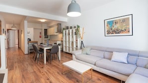 A modern apartment with a dining area, a living room, and a kitchen.