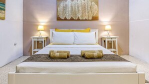 Une chambre à coucher comprenant un lit, deux tables de chevet et une œuvre d’art accrochée au mur.