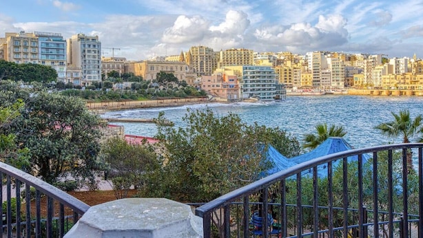 Un paysage urbain côtier offrant une vue sur la mer, des bâtiments et un escalier menant à une terrasse.