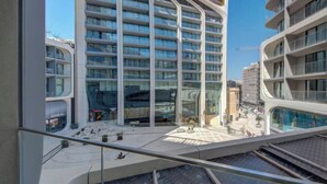 A modern building with a curved facade, large windows, and a balcony area. - Concierge Stay at Mercury Towers pjazza ! (San Ġiljan)