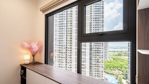 Una habitación moderna con un ventanal grande que da a un edificio alto y una piscina.