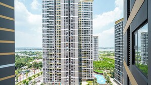 Un edificio residencial de gran altura con múltiples balcones, piscina y zonas verdes circundantes.