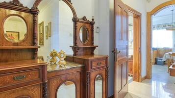 A spacious room with a large wooden dresser, a mirror, and a door leading to another area.
