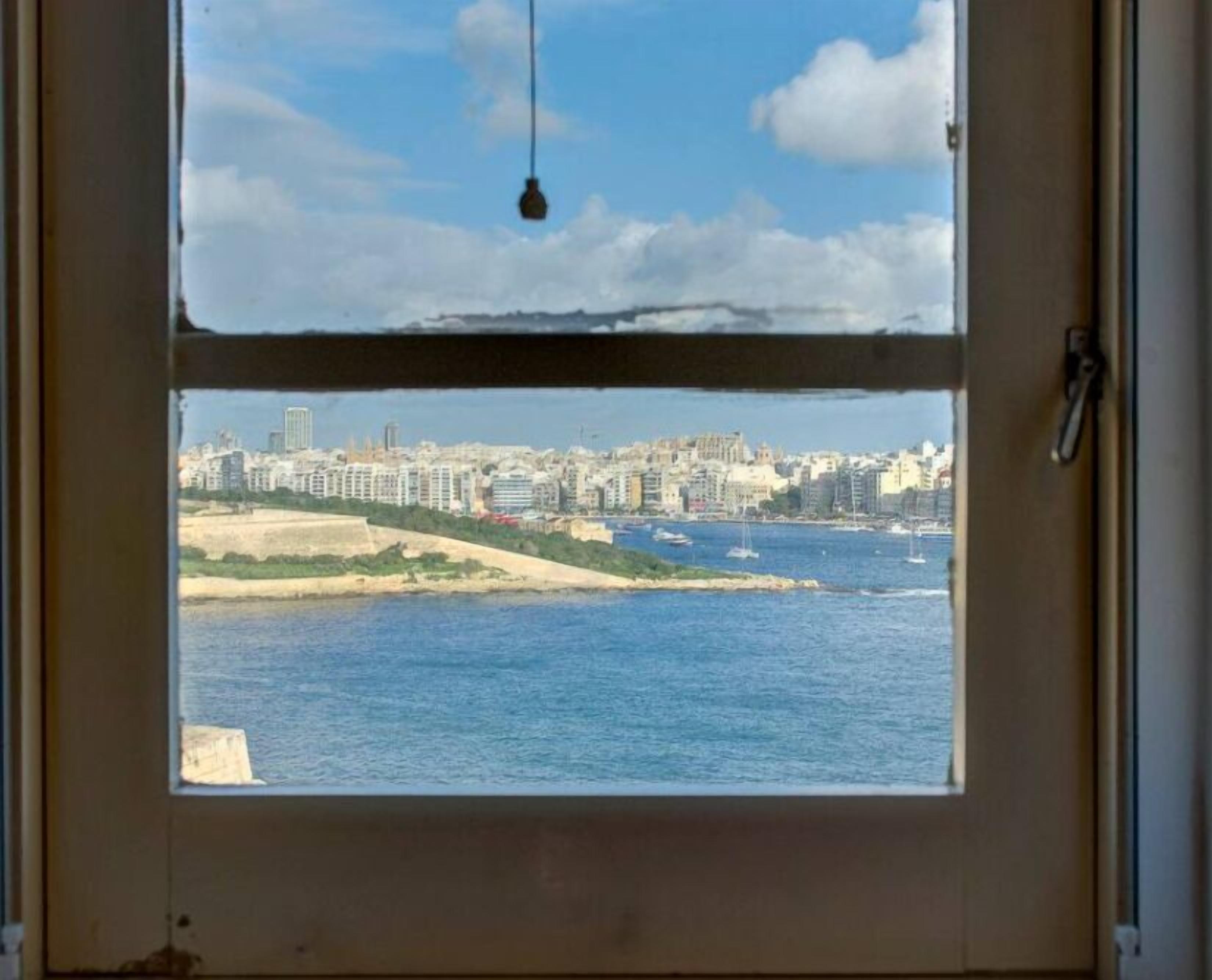 Blick aus einem Fenster auf eine Küstenstadt mit Gebäuden und einem Strand.