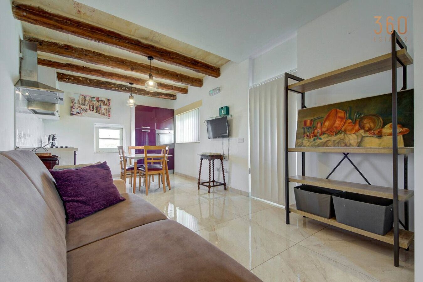 Una sala de estar con un sofá, un cuadro, un televisor y un comedor con sillas y una mesa.