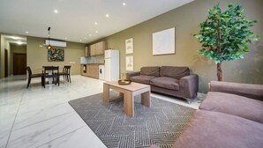 Un salon moderne avec un canapé, une table basse et un coin repas.