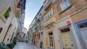 A narrow street lined with historic buildings, featuring balconies, traditional shutters, and a 'no entry' sign. - Cozy 1BR Apt in Birgu – Traditional Maltese Charm (Birgu)