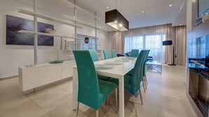 A modern dining area with a white table, teal chairs, and a minimalist design.