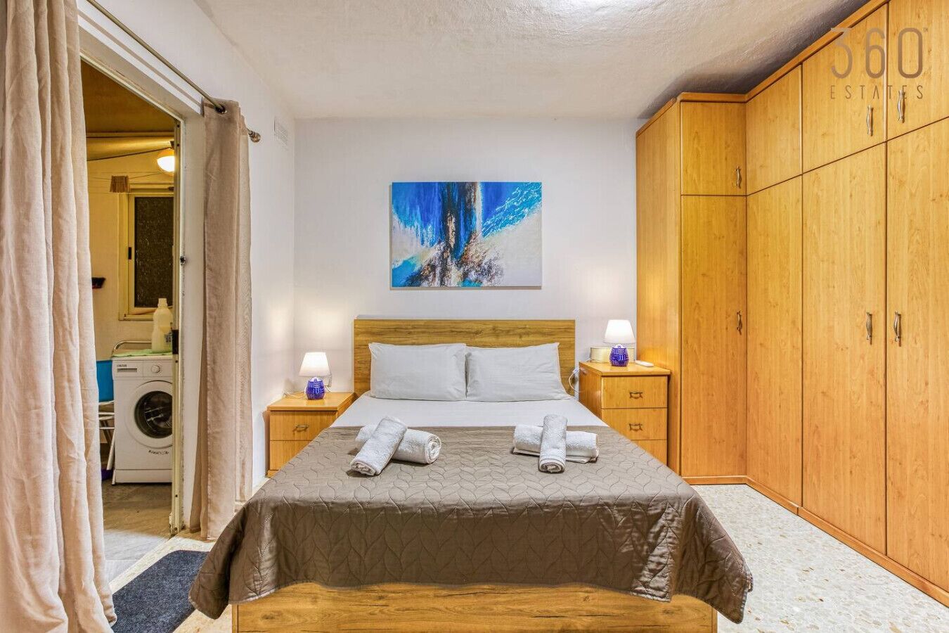 Une chambre à coucher avec un lit, un lave-linge et une armoire.