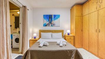 Une chambre à coucher avec un lit, un lave-linge et une armoire.