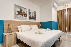 A hotel room with a large bed, two bedside tables, and artwork on the wall. - A beautiful 4BR heaven close to the beach w/WIFI (Wied il-Għajn)