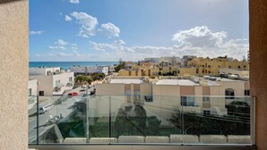 A residential area with buildings, a clear sky, and a view of the sea. - A beautiful 4BR heaven close to the beach w/WIFI (Wied il-Għajn)