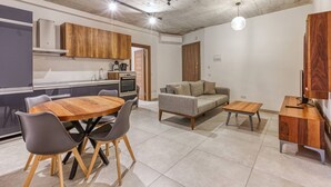 A modern living space with a dining area, a sofa, and a small table.