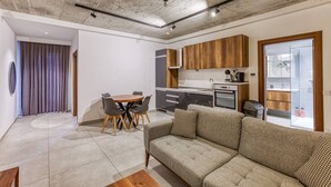 A modern apartment with a dining area, kitchen, and living room.