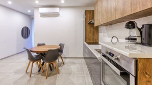 Una cocina moderna con armarios de madera, encimera de mármol y horno empotrado.