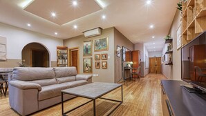 A spacious living room with a leather sofa, a coffee table, and a dining area with a table and chairs. - Lovely spacious 3BR Apt in the heart of St`Julians (San Ġiljan)