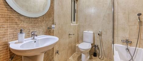 A bathroom with a sink, toilet, and bathtub.