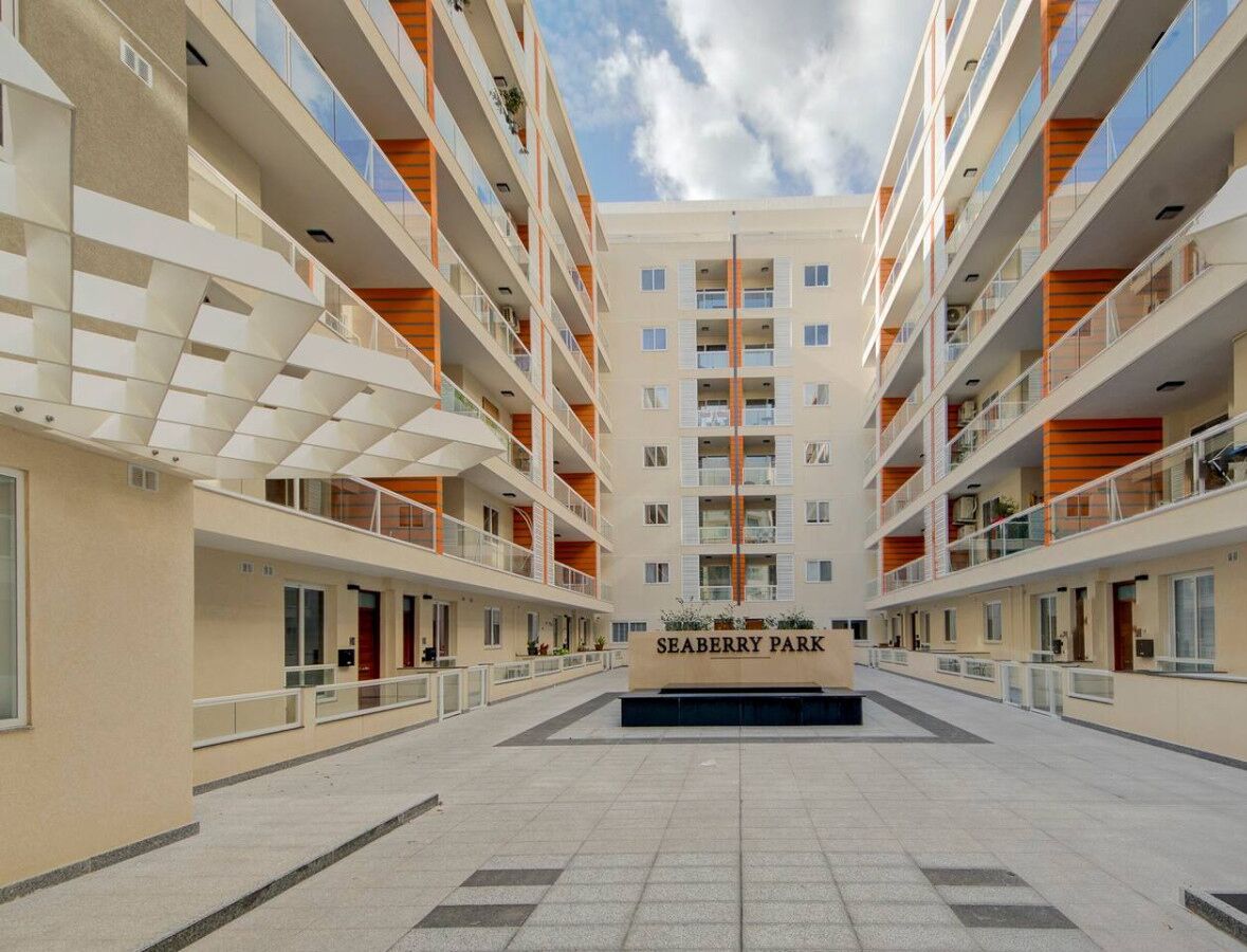 Un immeuble moderne à plusieurs étages doté d’une cour intérieure, qui porte l’inscription « SEABERRY PARK ».