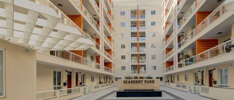 Un immeuble moderne à plusieurs étages doté d’une cour intérieure, qui porte l’inscription « SEABERRY PARK ».