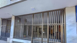 A building facade with a metal gate, a tiled entrance, and a small step leading to the door. - SUH Flamengo 01 Praia Studio Dreams (Rio de Janeiro)