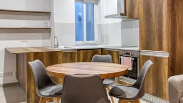 Una cocina moderna con una isla de madera, una mesa redonda y cuatro sillas.
