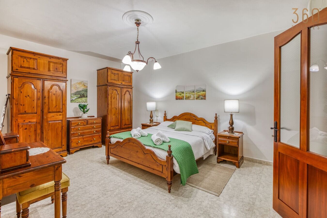 A bedroom with a wooden bed, a nightstand, a dresser, and a wardrobe.