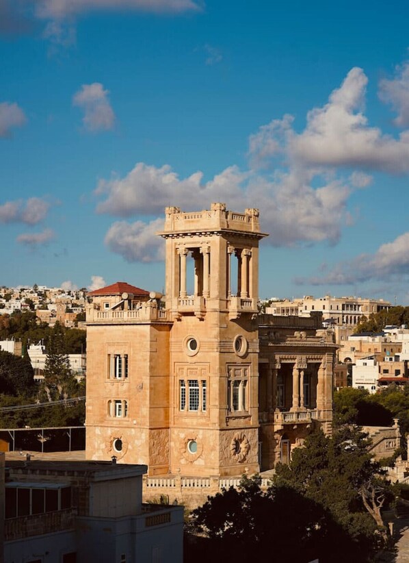A historic building with a prominent tower and classical architecture, surrounded by a residential area.