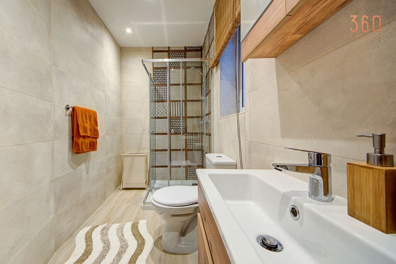 Une salle de bain moderne équipée d’une douche, de toilettes et d’une baignoire.