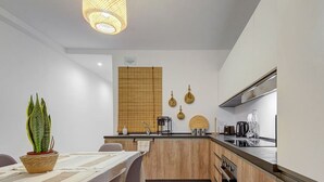 A modern kitchen with wooden cabinets, a built-in oven, and a stainless steel range hood.