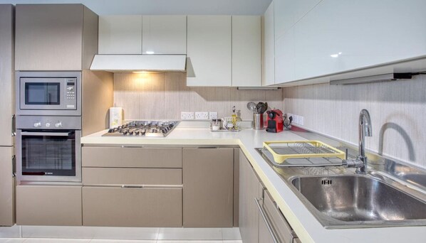 Una cocina moderna con horno integrado, microondas y cocina a gas.