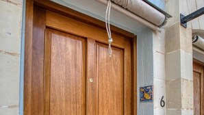 A wooden double door with a handle, a number '6' on the wall, and a small window above the door. - Stylish St. Julian’s 1BR home, Cozy & Central! (St. Julian`s)