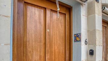 A wooden double door with a handle, a number '6' on the wall, and a small window above the door.
