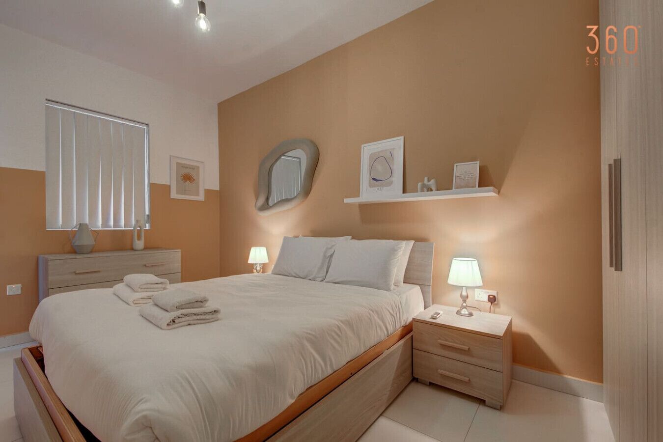 Un dormitorio moderno con una cama grande, mesitas de noche, un espejo y una estantería con objetos decorativos.