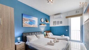 Un dormitorio con dos camas, un armario, un cuadro, un reloj y una ventana con vistas.