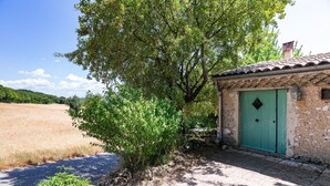 A rustic building with a green door, surrounded by trees and a field. - Holiday Home 'Chant D'Etoiles' with Private Pool (Roynac)