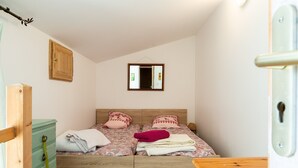 A bedroom with a bed, a wooden dresser, a mirror, and a door. - Holiday Home 'Chant D'Etoiles' with Private Pool (Roynac)