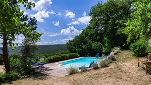 A swimming pool with lounge chairs, surrounded by trees and a hilly landscape. - Holiday Home 'Chant D'Etoiles' with Private Pool (Roynac)