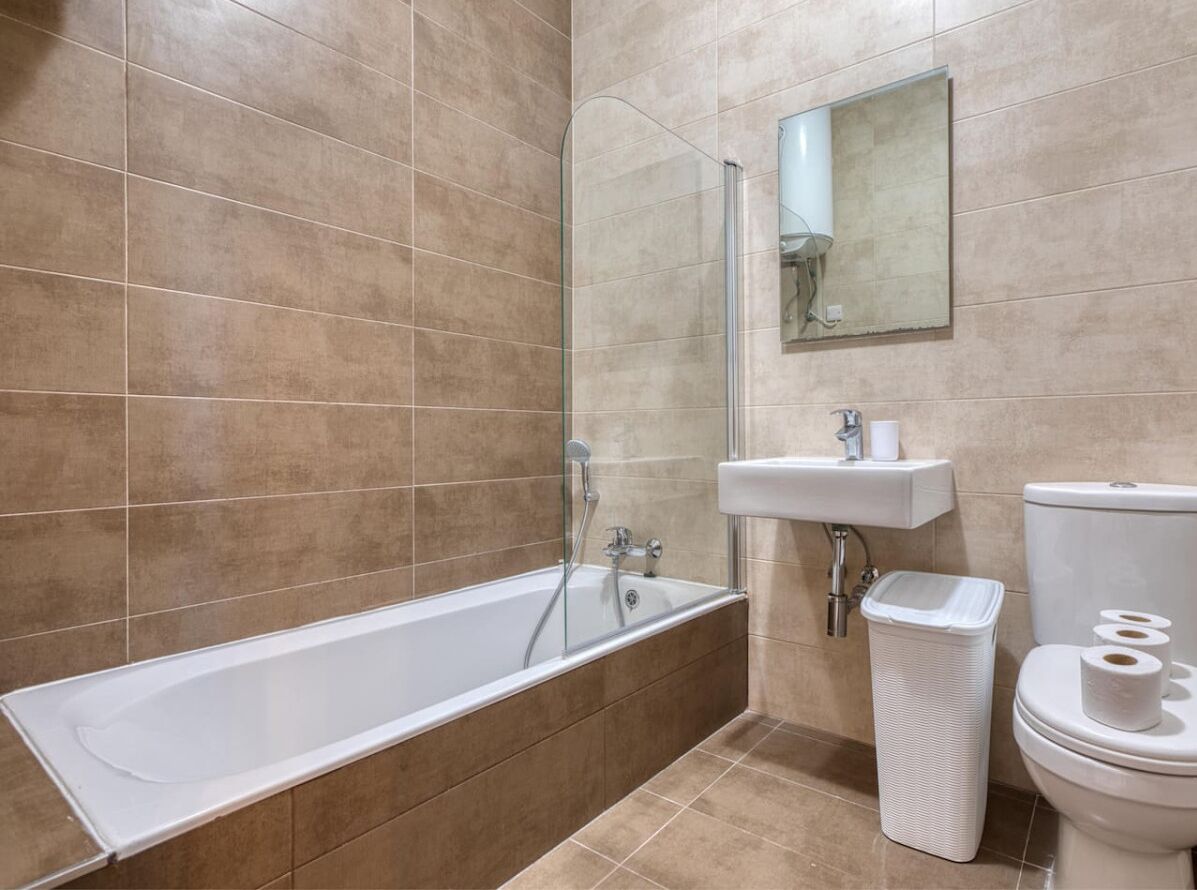 Une salle de bain moderne avec une douche à parois de verre, un lavabo blanc et des toilettes.
