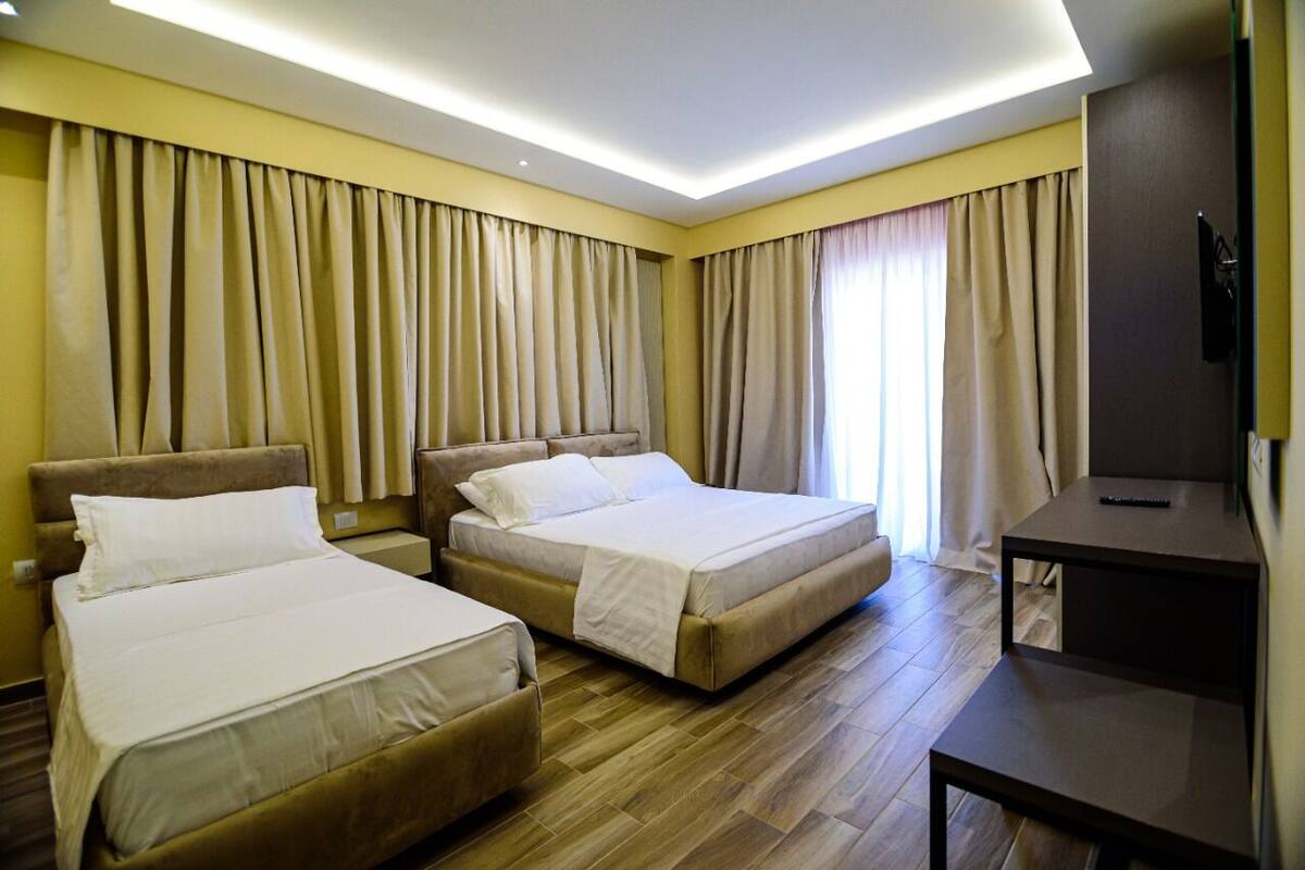 Una habitación de hotel con dos camas, un escritorio y un televisor.