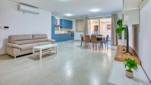 A modern apartment with a living room, dining area, and kitchen.