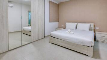 Una camera da letto con un letto, comodini, uno specchio e un armadio.
