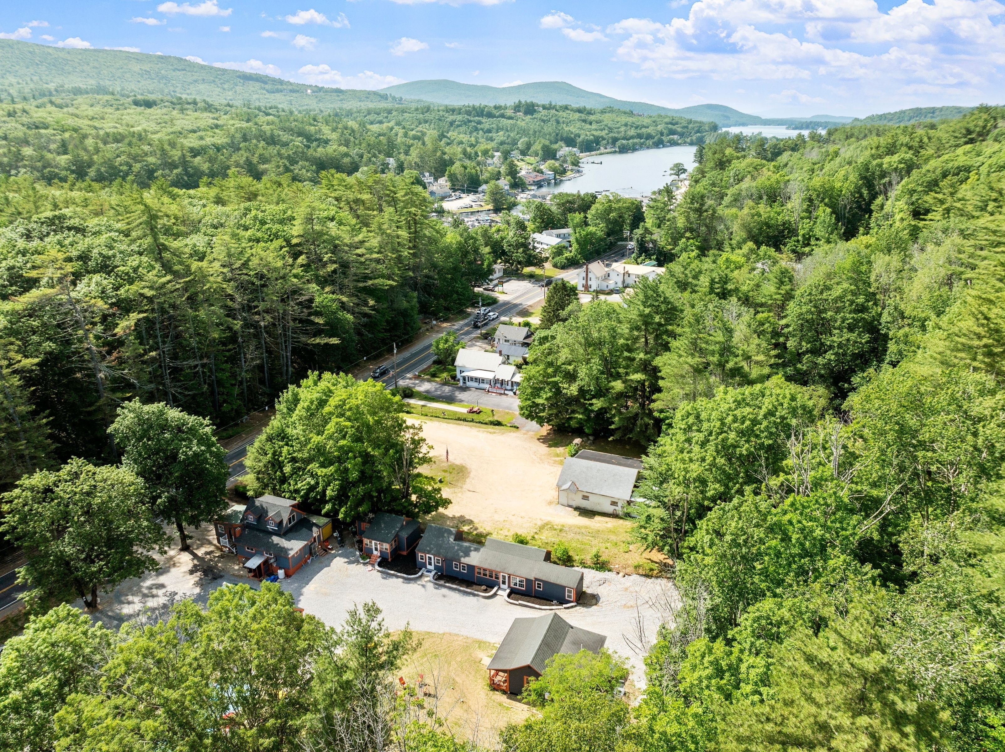 A residential area with houses, a road, and a lake in the background.