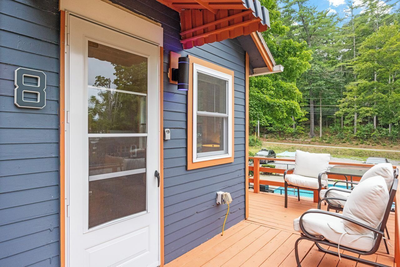 A house with a deck, a number 8 sign, and a pool.