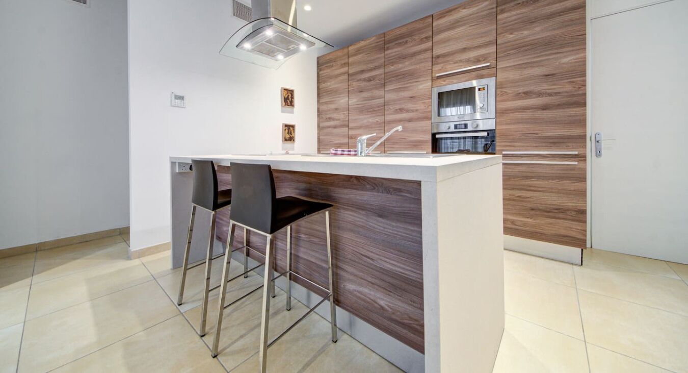 Una cucina moderna con isola centrale, elettrodomestici in acciaio inossidabile e un design minimalista.