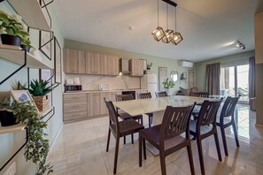 Une cuisine moderne avec des meubles en bois, un îlot central doté de sièges et un éclairage suspendu.